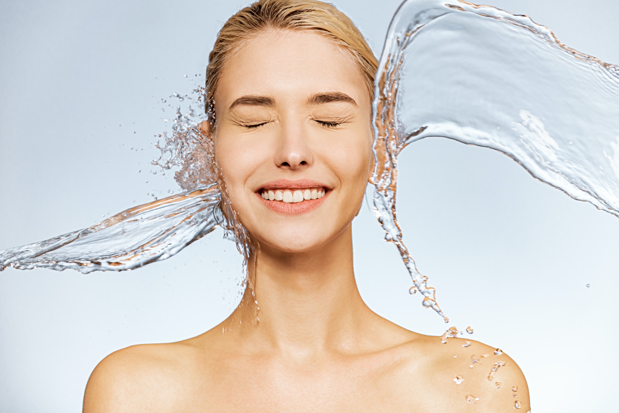 Photo of young woman with clean skin and splash of water.